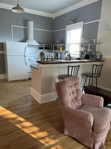 a kitchen with a chair and a white refrigerator at 150-year-old Lincolnville cottage 3bedroom 2bath in St. Augustine