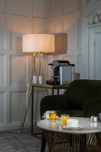 a lamp in a living room with a table at Hatherley Manor Hotel & Spa in Gloucester