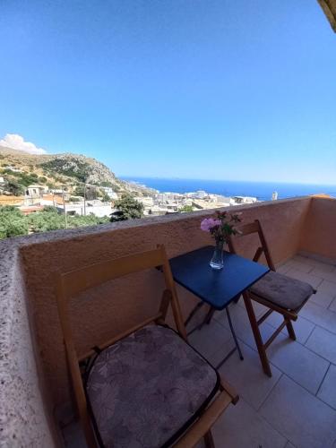 a table and two chairs on a balcony with the ocean at Castro Kerame in Kerames