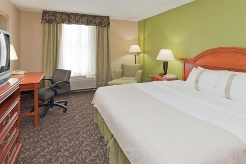 una camera d'albergo con letto, scrivania e TV di Park Hospitality Mansfield a Mansfield