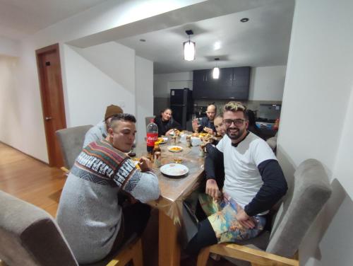 a group of men sitting around a table eating at linda house cusco in Cusco