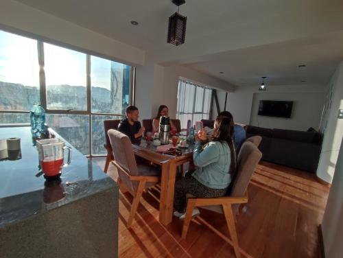 a group of people sitting around a table in a living room at linda house cusco in Cusco