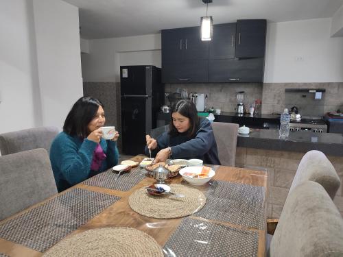 two women sitting at a table eating food at linda house cusco in Cusco