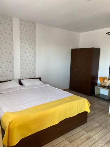 a bedroom with a large bed with a yellow blanket at Casa de la Corbu in Corbu