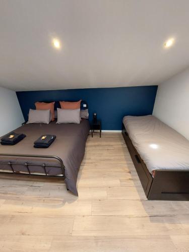 2 Betten in einem Zimmer mit blauen Wänden in der Unterkunft Emilie une nuit - 3 chambres au 2e étage - maison avec chats in Vandières