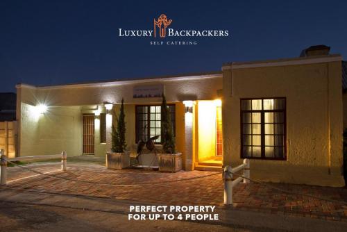 a building with a sign that reads premier property for up to a people at Luxury Backpackers in Port Elizabeth