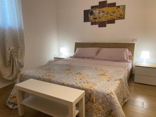 Un dormitorio con una cama con una mesa y dos lámparas. en La Dependance al Piccolo Borgo, en Crispiano