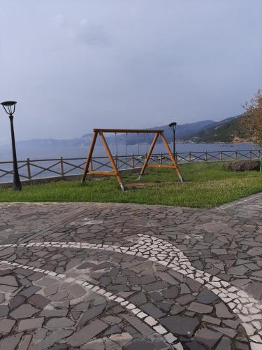 a park with a bench on the side of the water at Luna e Mare in Cala Gonone