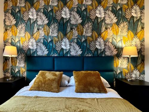 1 dormitorio con 1 cama y papel pintado con motivos florales en Apartamenty Villa Fiori, en Sobieszewska Pastwa