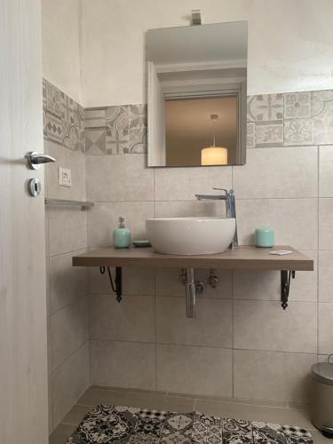 La salle de bains est pourvue d'un lavabo et d'un miroir. dans l'établissement La Dependance al Piccolo Borgo, à Crispiano