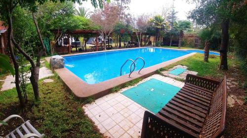uma piscina com um banco num quintal em Lodge Spa Melipilla em Melipilla