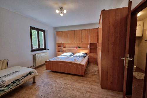 a bedroom with a bed and a wooden door at Počitniška hiša Miklavčič Primorska in Divača