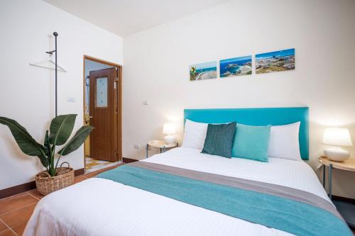a bedroom with a large bed with a blue headboard at 好室包棟民宿 in Taitung City