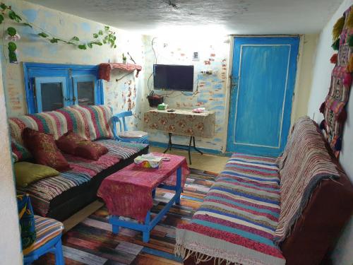Rural Guest House فندق البيت الريفي في طنطا: غرفة معيشة مع أريكة وطاولة
