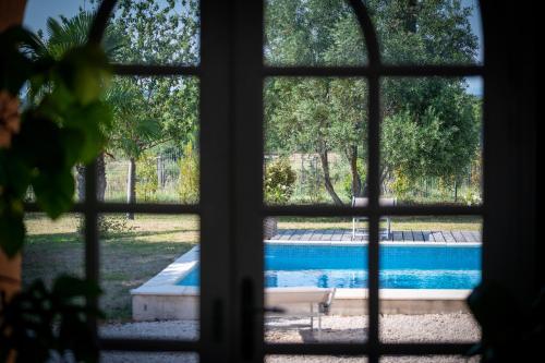 a window view of a swimming pool from a house at La Gourgasse Vieille in Béziers