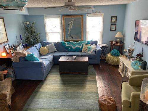 BEACH HAVEN Dog friendly farmette Great for 2 couples في بيرلين: غرفة معيشة مع أريكة زرقاء وطاولة