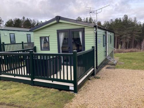 a green mobile home with a large deck at Liberty-5 in Slaley