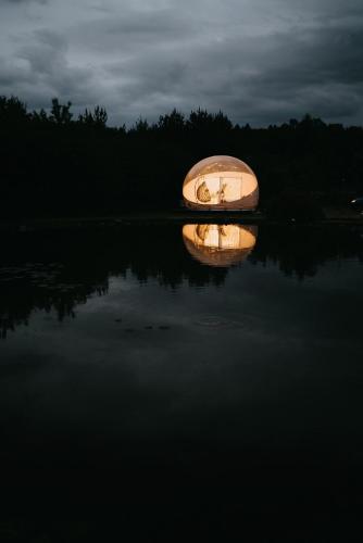 a small boat in the middle of a lake at night at W BAŃCE Glamping in Łódź