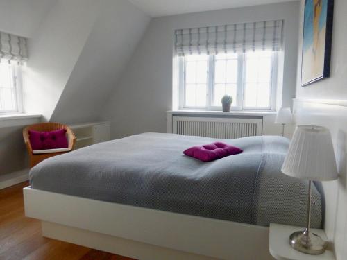a bedroom with a large bed with purple pillows on it at Haus Muehlenblick in Borgsum
