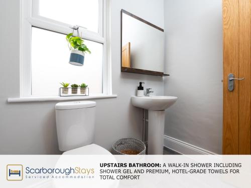 a bathroom with a toilet and a sink and a window at Scarborough Stays - Ashville Lodge - 5 Bedroomed house - Sleeps 9 in Scarborough