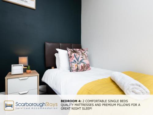 a bedroom with a bed and a nightstand with a pillow at Scarborough Stays - Ashville Lodge - 5 Bedroomed house - Sleeps 9 in Scarborough