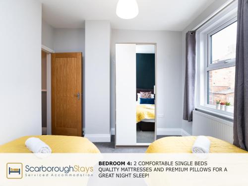 a bedroom with two beds and a mirror at Scarborough Stays - Ashville Lodge - 5 Bedroomed house - Sleeps 9 in Scarborough