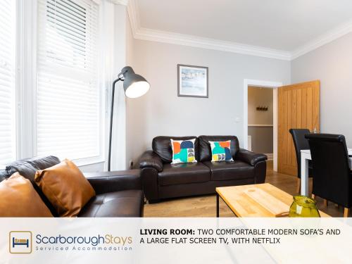 a living room with a couch and a coffee table at Scarborough Stays - Ashville Lodge - 5 Bedroomed house - Sleeps 9 in Scarborough