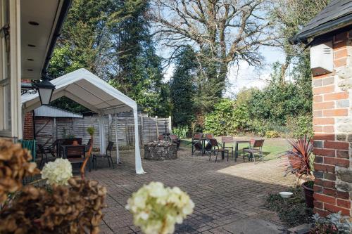 a patio with a white canopy and tables and chairs at The Jolly Drover in Liss
