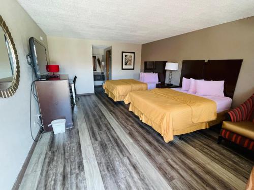 Habitación de hotel con 2 camas y sofá en Royal Inn & Suites, en Mountain Grove