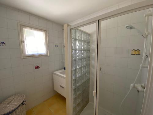 een badkamer met een douche, een toilet en een raam bij ORIANE Jolie maison proche plage in Le Bois-Plage-en-Ré