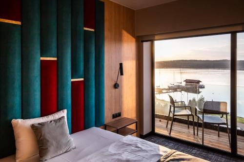 a bedroom with a bed and a large window with a balcony at OTTON-Charzykowy Bed&Restaurant in Chojnice