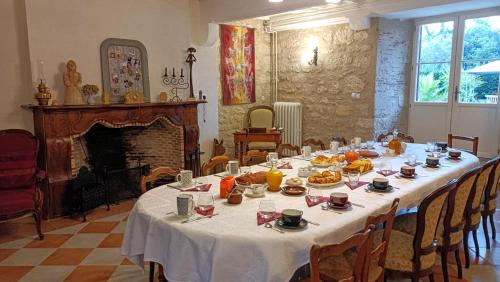 Cette chambre dispose d'une table avec de la nourriture et d'une cheminée. dans l'établissement Domaine du Noble, à Saint-Jean-de-Thurac