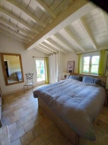 - une chambre avec un grand lit dans une pièce dotée de fenêtres dans l'établissement Maison charmante avec jacuzzi à Saint-Ciers-de-Canesse, à Saint-Ciers-de-Canesse