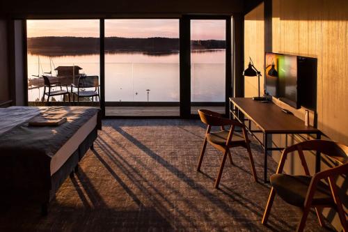 a room with a bed and a desk and a table and chairs at OTTON-Charzykowy Bed&Restaurant in Chojnice