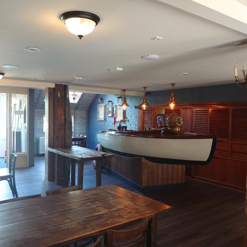a restaurant with a large boat on the wall at De Cyprian Bed & Breakfast in Baaiduinen