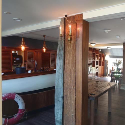 a bar in a restaurant with a wooden counter at De Cyprian Bed & Breakfast in Baaiduinen