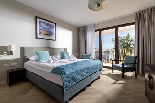 a hotel room with a bed and a balcony at Hotel Meridian in Chałupy