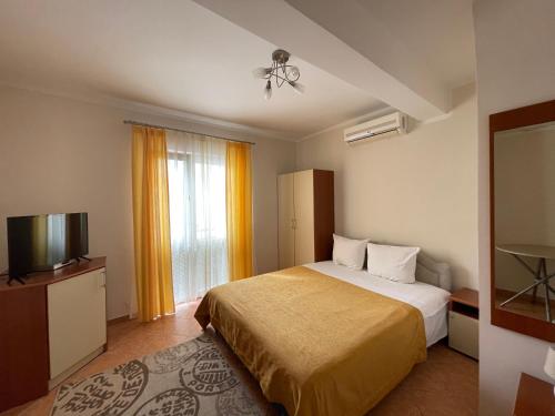 a hotel room with a bed and a television at Villa Semashko in Bar