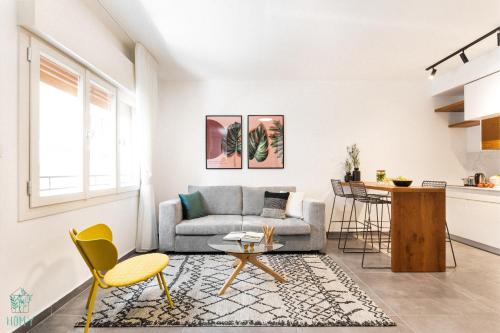 ein Wohnzimmer mit einem Sofa und einem Tisch in der Unterkunft HA MESILLA - Modern Collection - By HOMY in Tel Aviv