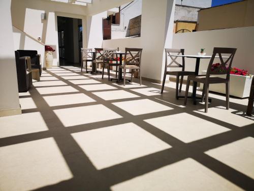 a room with tables and chairs and shadows on the floor at Hotel Mare Blu in Torre dell'Orso