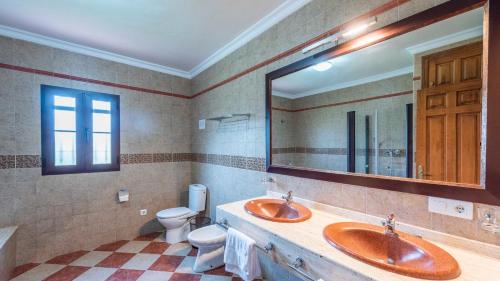 uma casa de banho com 2 lavatórios, um WC e um espelho. em Casa Rural Cortijo Picuales Torrox by Ruralidays em Torrox