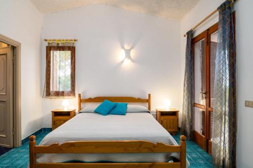 a bedroom with a bed with blue pillows at Villa Bados 8 - Klodge in Olbia