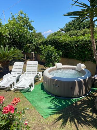 - un bain à remous dans une cour avec 2 chaises longues dans l'établissement Villa Saturno, à Tropea