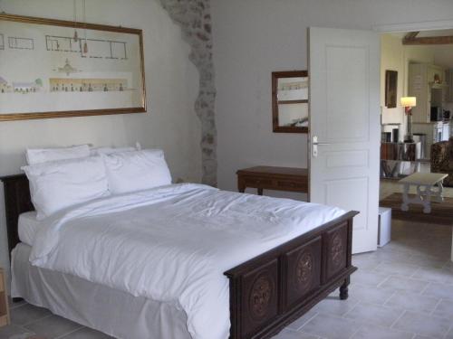 een slaapkamer met een groot bed met witte lakens bij Gîte de l'Octroy Poitou in Oiron