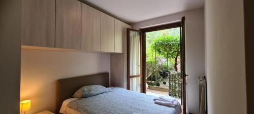 Un dormitorio con una cama azul y una ventana en Casa Vacanza Monalba sul lago d'Iseo, en Predore