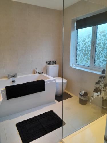 a bathroom with a bath tub and a toilet at Nar river b&b in Kings Lynn