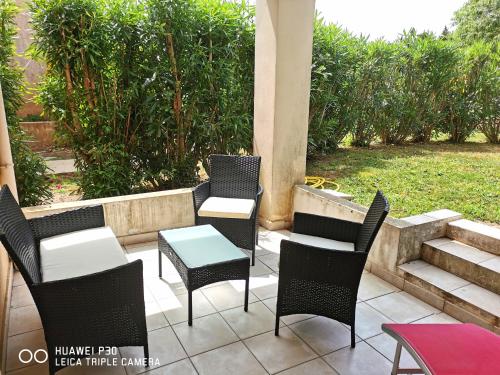 une terrasse avec des chaises, une table et des escaliers. dans l'établissement Studio 201 - LES SUITES DE ROBINSON - Résidence avec piscine en bord de Siagne, à Mandelieu-La-Napoule, à Mandelieu-la-Napoule