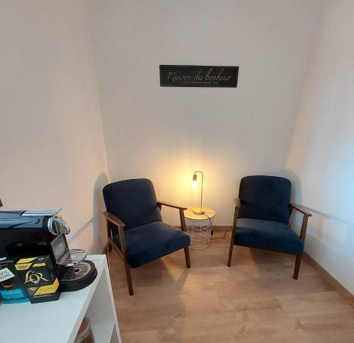 two blue chairs and a table in a room at Emilie une nuit - 3 chambres au 2e étage - maison avec chats in Vandières