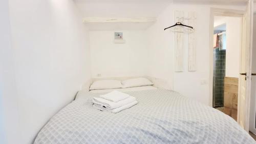 Una cama blanca con dos toallas encima. en The Bungalow, en Brasov