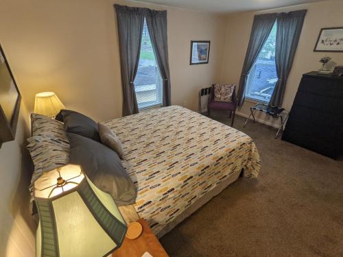 a bedroom with a bed and two windows at The Estate Loft in Downtown Milford in Milford